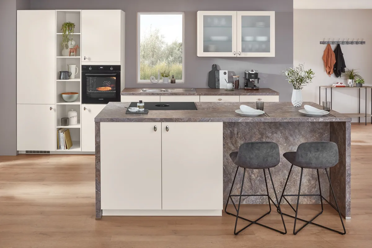 Küche in Magnolia mit Kochinsel, Arbeitsplatte in Quarzit-Optik und zwei Barhockern